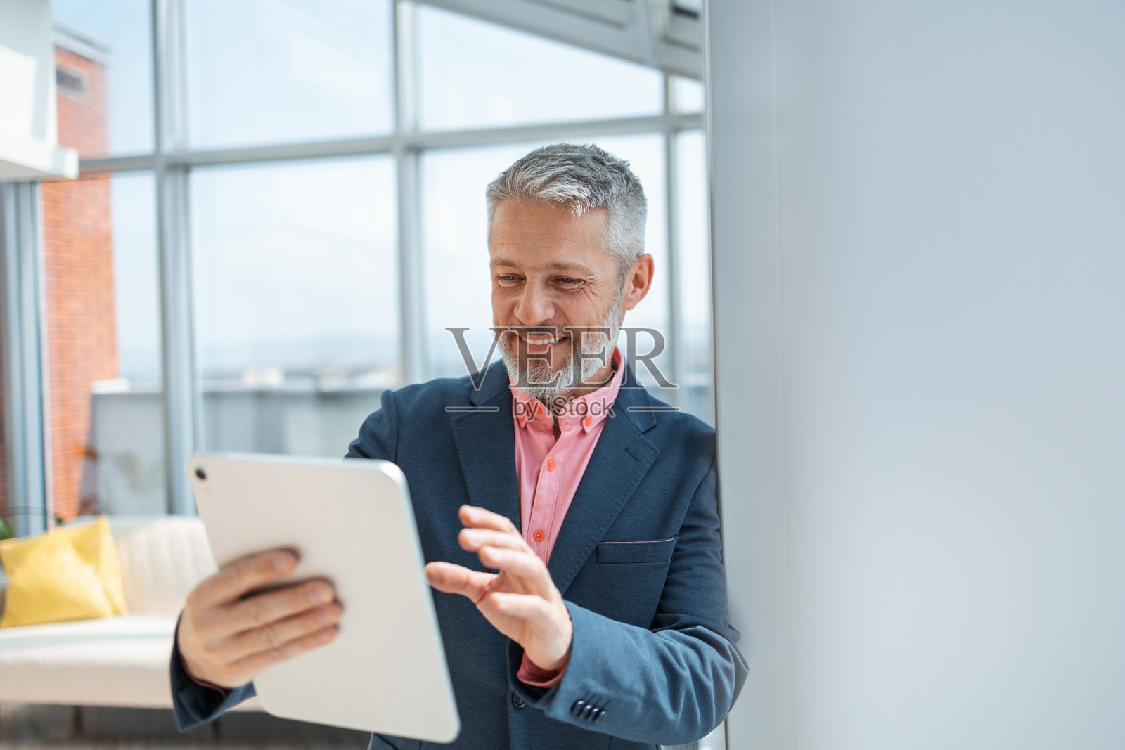 微笑的专业人士在明亮现代的办公室内使用数字平板电脑照片摄影图片