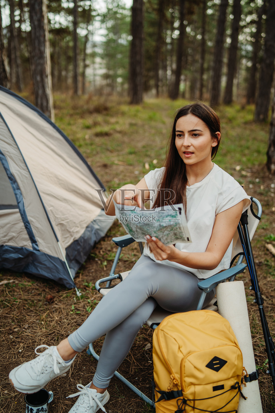 年轻的白人女性在风景如画的森林中为夜晚准备营地和篝火照片摄影图片