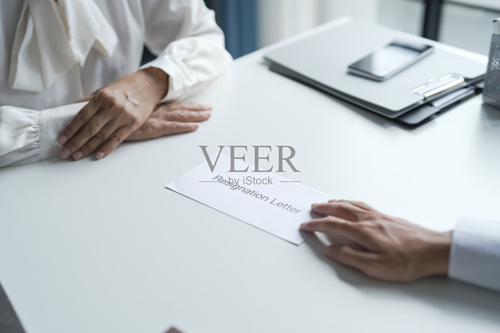 商务人士向老板发送辞职信，沮丧地抱着纸箱，站在办公室的桌子旁。照片摄影图片