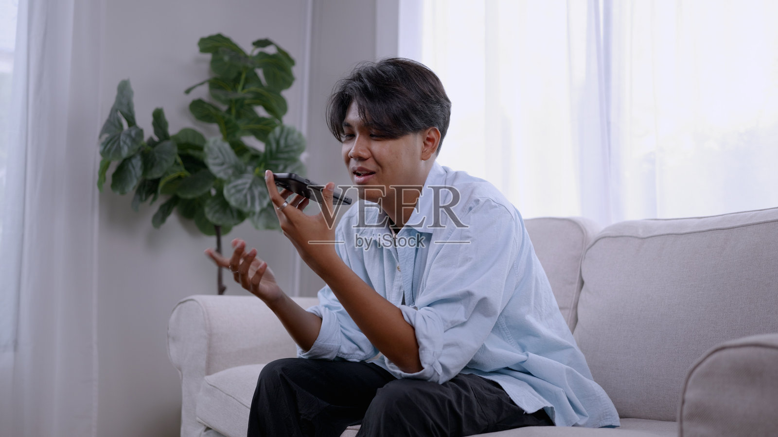 亚洲男子在手机上与人工智能沟通，处理工作相关任务，职场数字创新。照片摄影图片