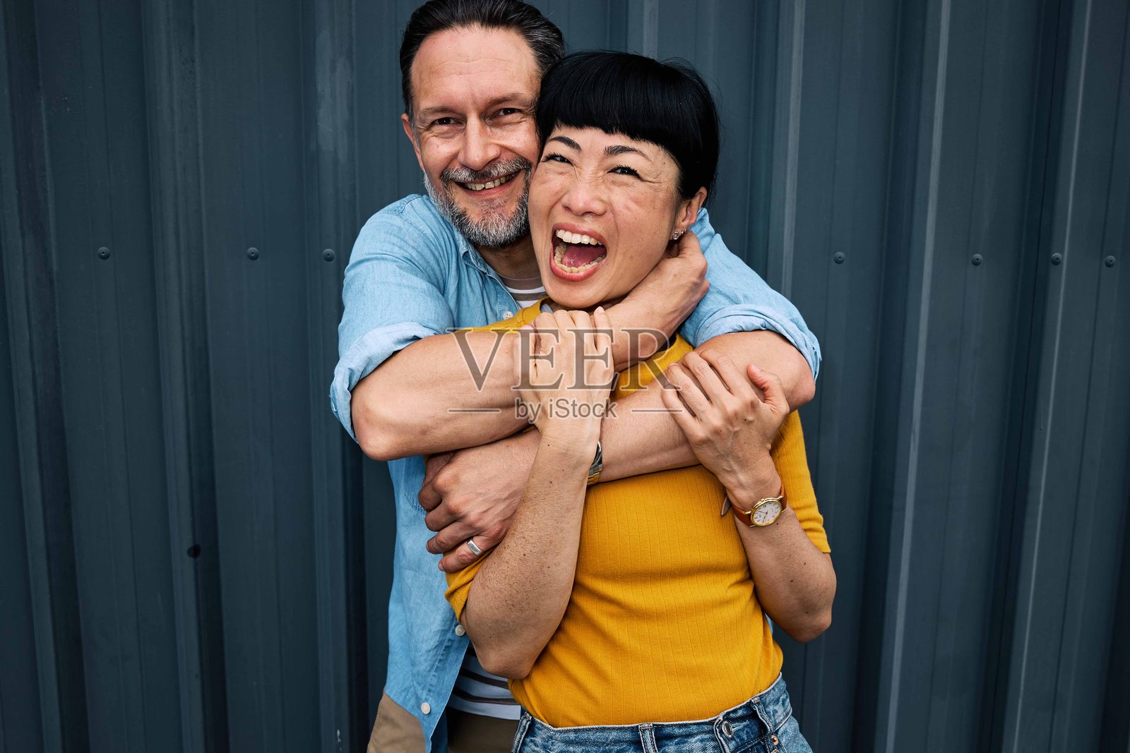 户外拥抱的中年多元文化情侣肖像。照片摄影图片