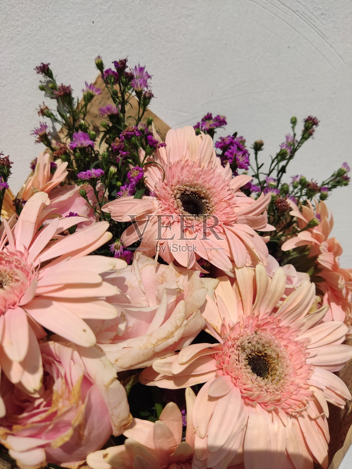 柔和粉色的菊花花束，配有棕色纸锥底座照片摄影图片