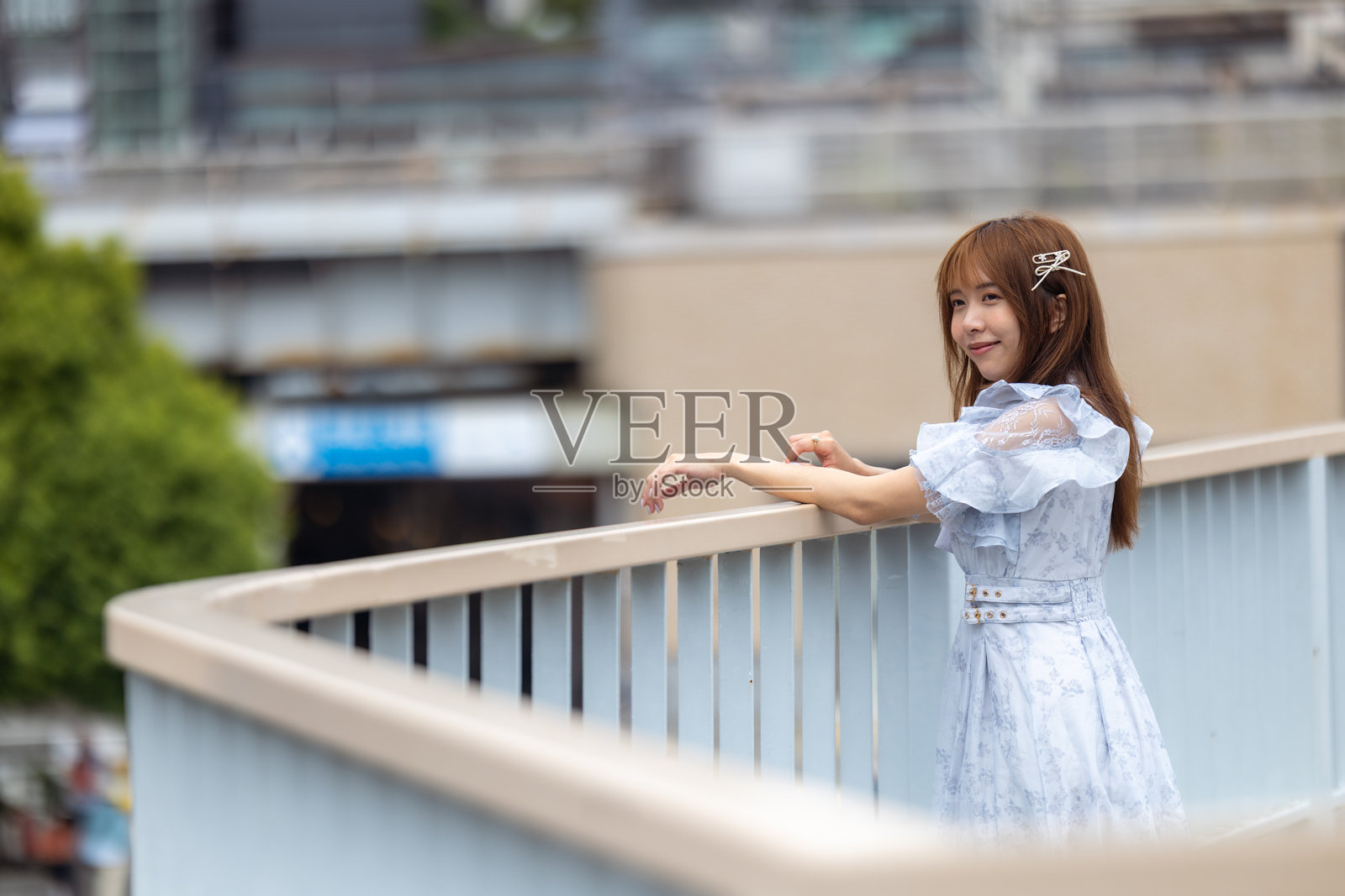 年轻女性游客在步行天桥上欣赏风景照片摄影图片