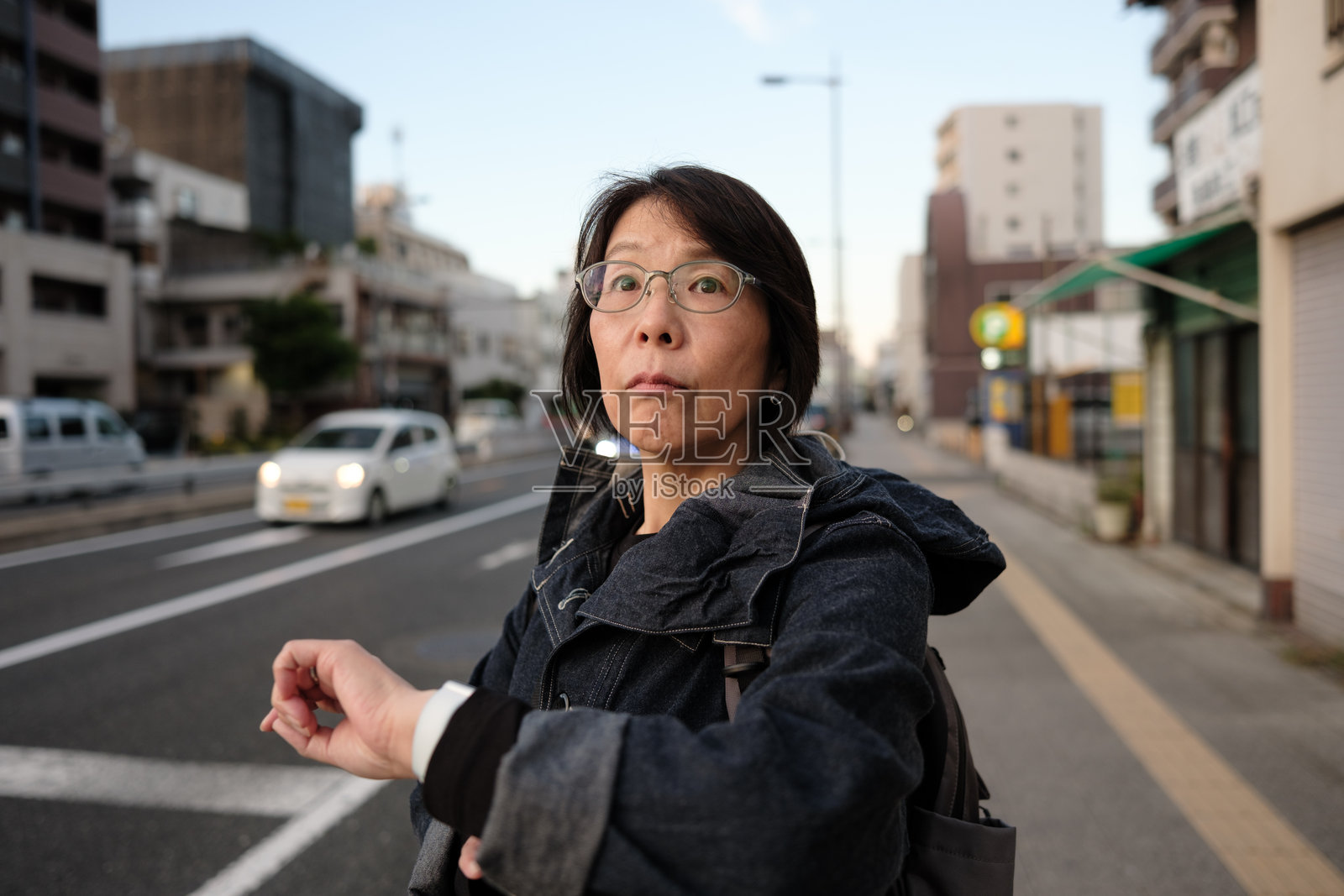 女人在街上查看时间照片摄影图片