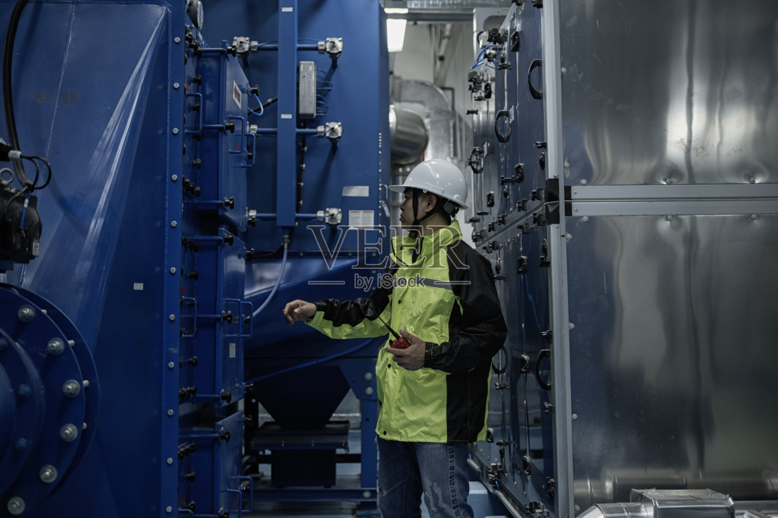 亚洲工程师在现代工业设施中进行检查。工程师在高科技工业设施中监控系统。照片摄影图片