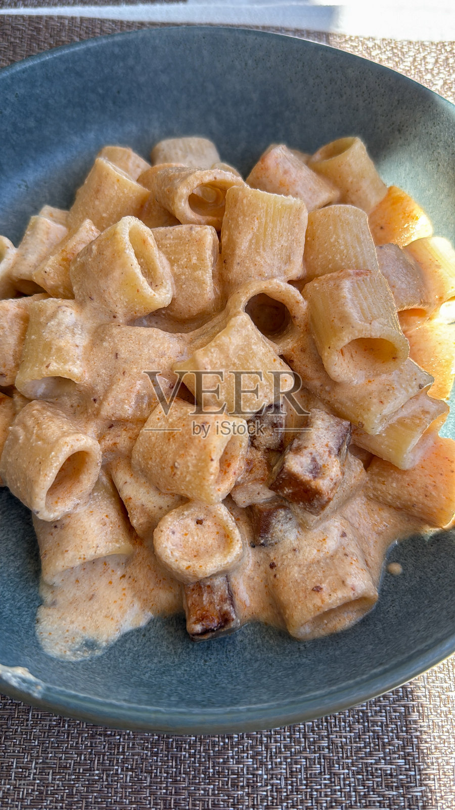 蓝色碗中的奶油意大利面配烤香肠照片摄影图片