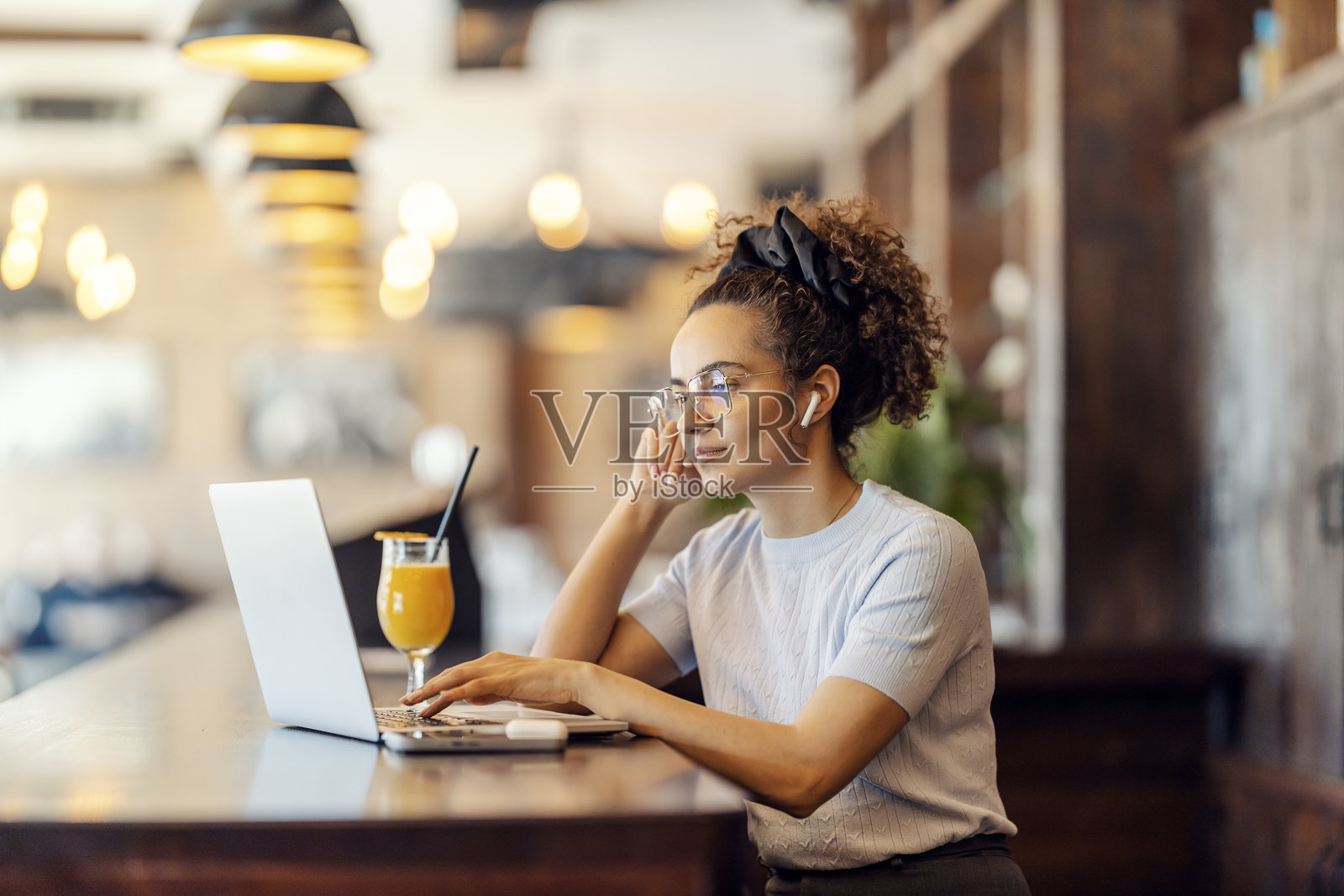 跨种族女性自由职业者坐在咖啡馆里使用笔记本电脑工作。照片摄影图片