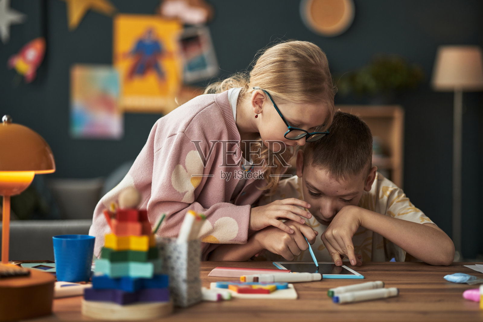 女孩帮助有残疾的男孩画画照片摄影图片