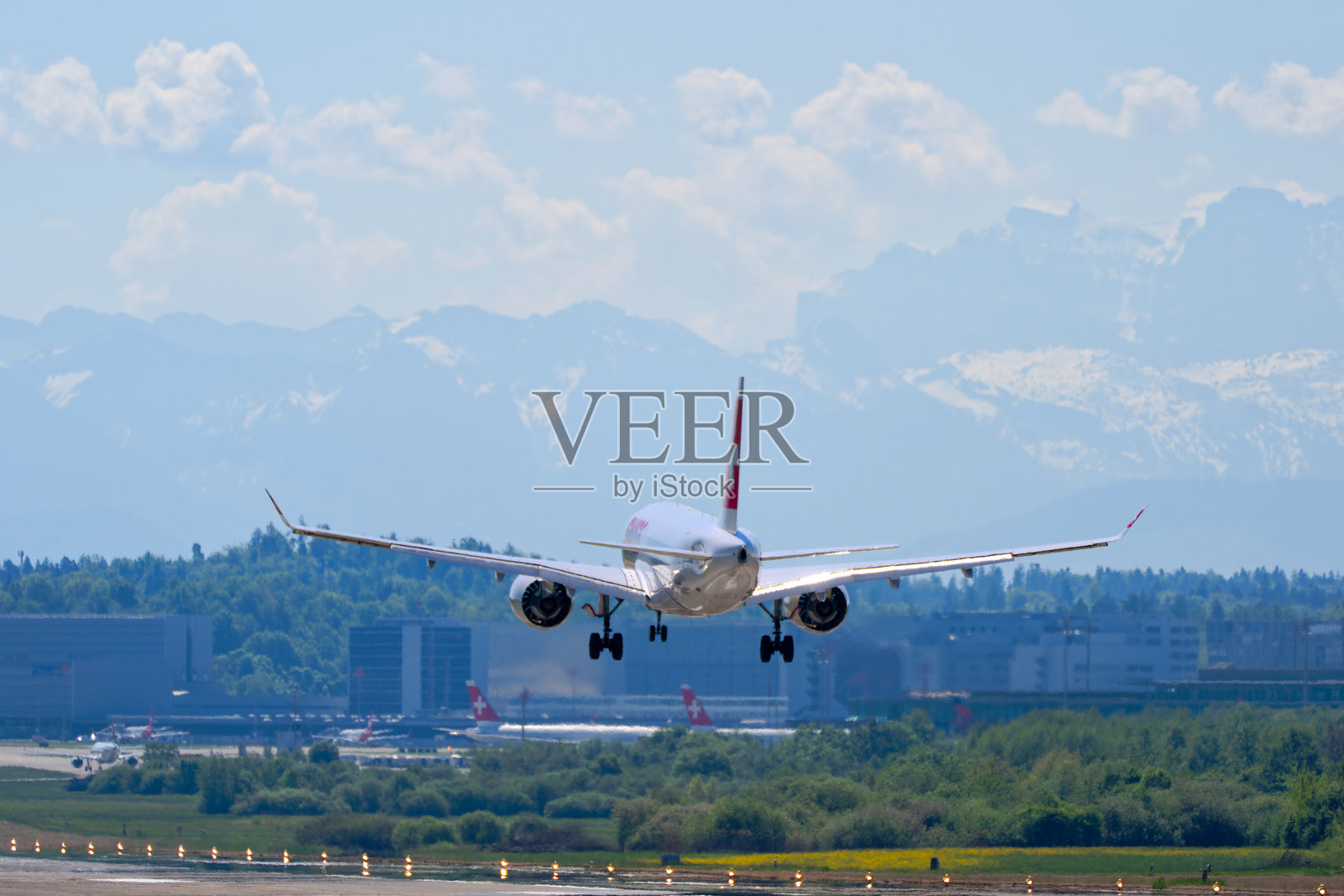 降落的瑞士空客A220-100客机，注册号HB-JBB，在阳光明媚的春天里降落在瑞士苏黎世克洛滕机场。照片摄影图片