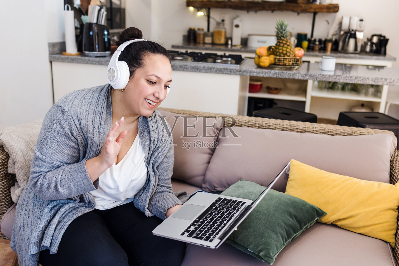 年轻的拉丁裔丰满女性在墨西哥的家中沙发上使用笔记本电脑工作照片摄影图片