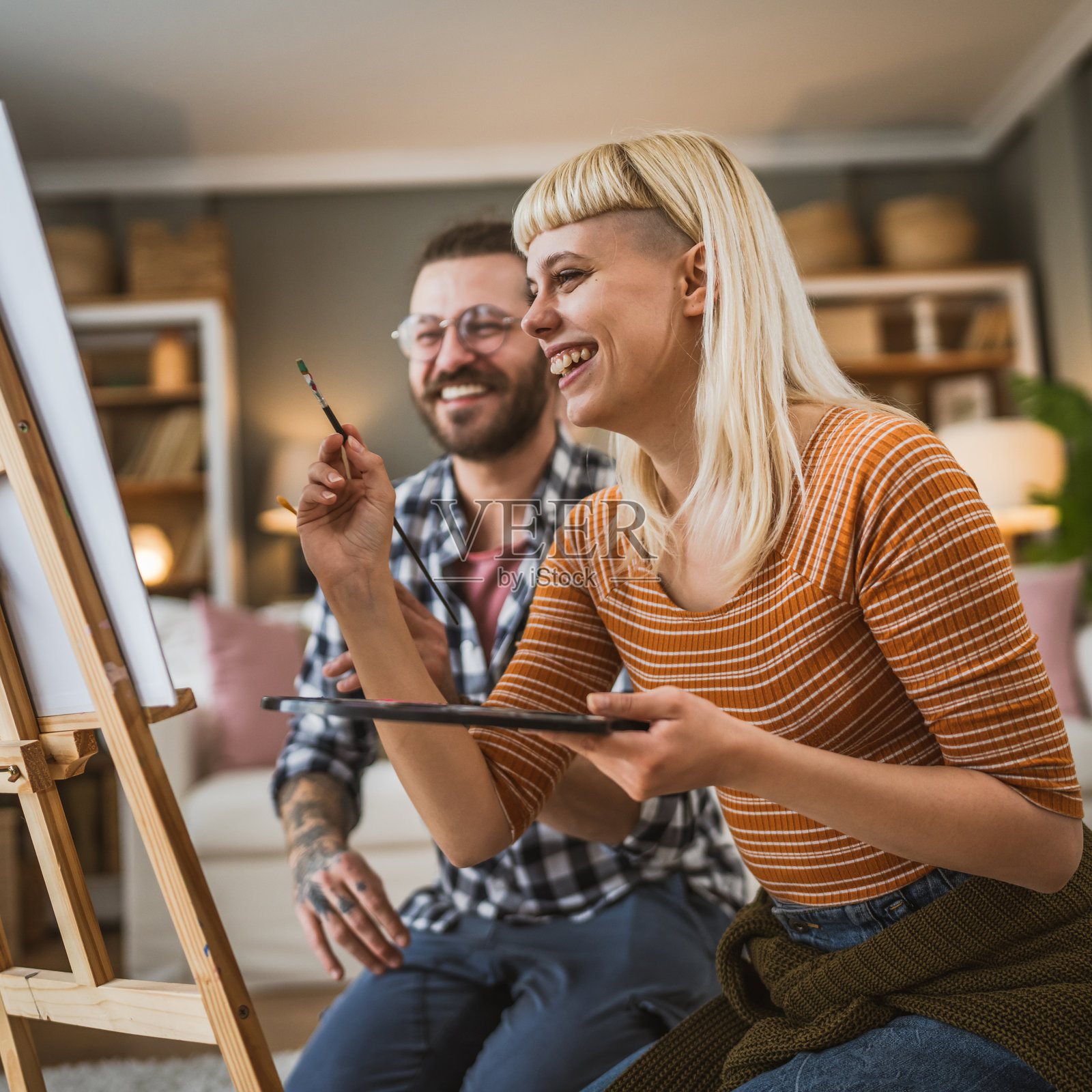 一对男女在家中悠闲地在画架上画画照片摄影图片