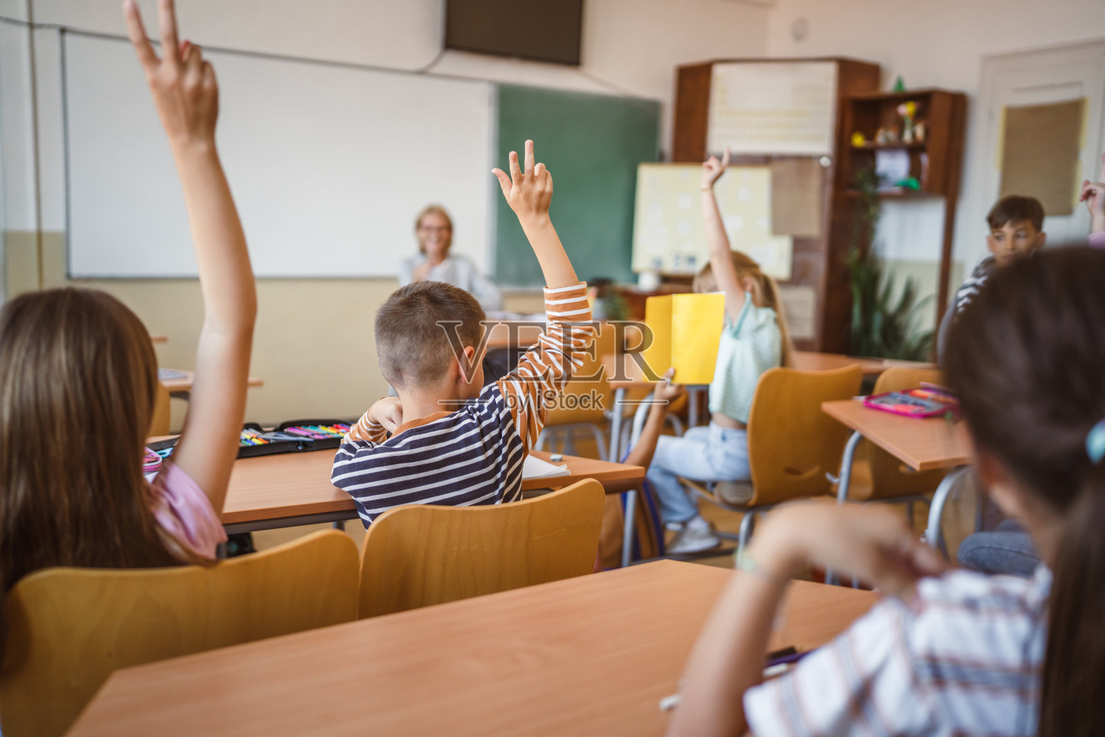 学校孩子们在课堂上举手回答问题照片摄影图片