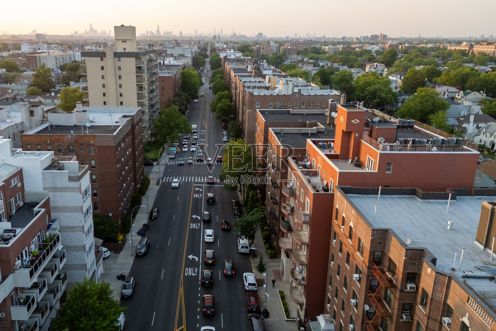 繁忙的城市街道上，人们走动，汽车驶过，背景是高楼大厦。照片摄影图片