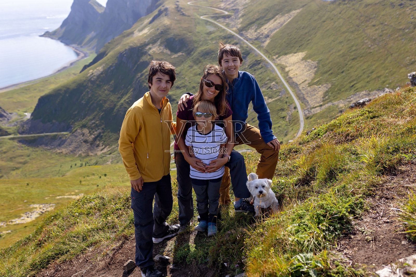 带着孩子和狗的家庭在瓦尔厄岛徒步旅行，最著名的徒步路线海恩，孩子们在阳光明媚的日子里享受徒步旅行。照片摄影图片