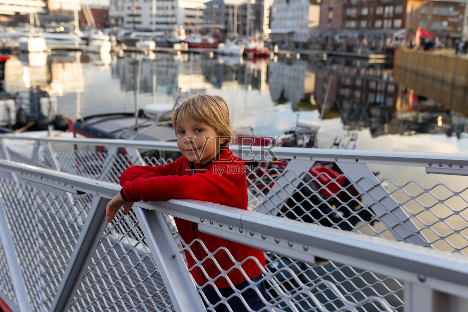 可爱的学龄前男孩，在阳光明媚的特罗姆瑟，参观挪威北部最大的城市。照片摄影图片