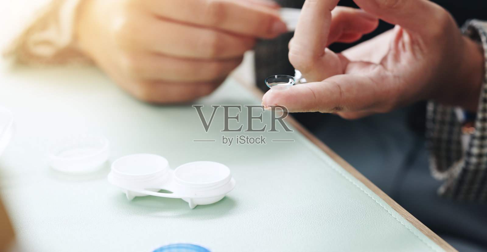 眼科，隐形眼镜和人的手指用于眼部护理、健康与保健，配有容器。医疗保健，特写镜头和手部与眼镜，涉及视力、视力检查和眼科处方。照片摄影图片