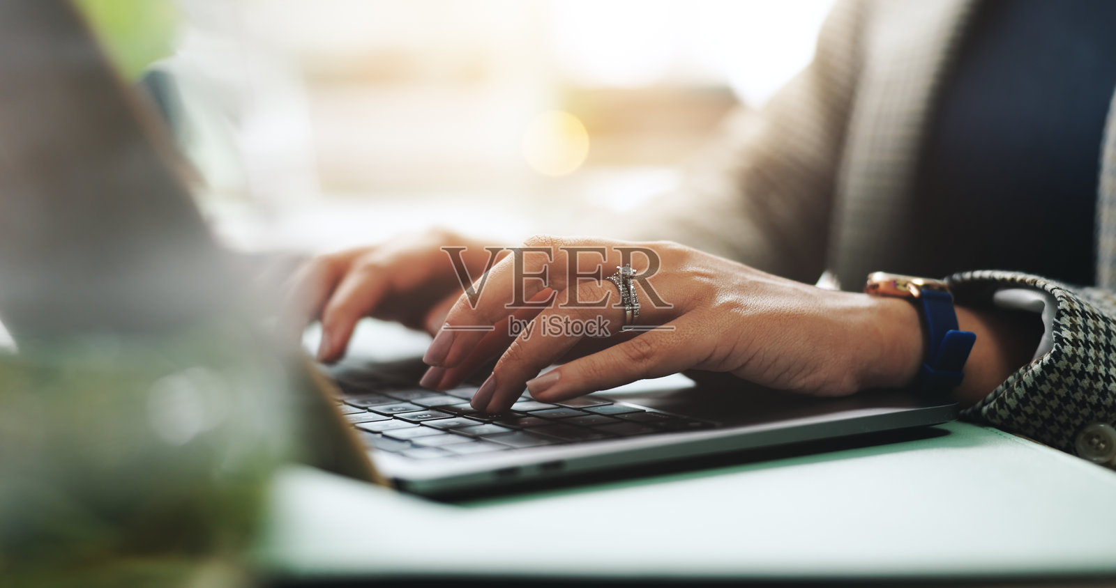 商务女性在办公室使用笔记本电脑进行研究或新闻报道，手部特写，专注于撰写文章、创意故事和电子邮件。照片摄影图片