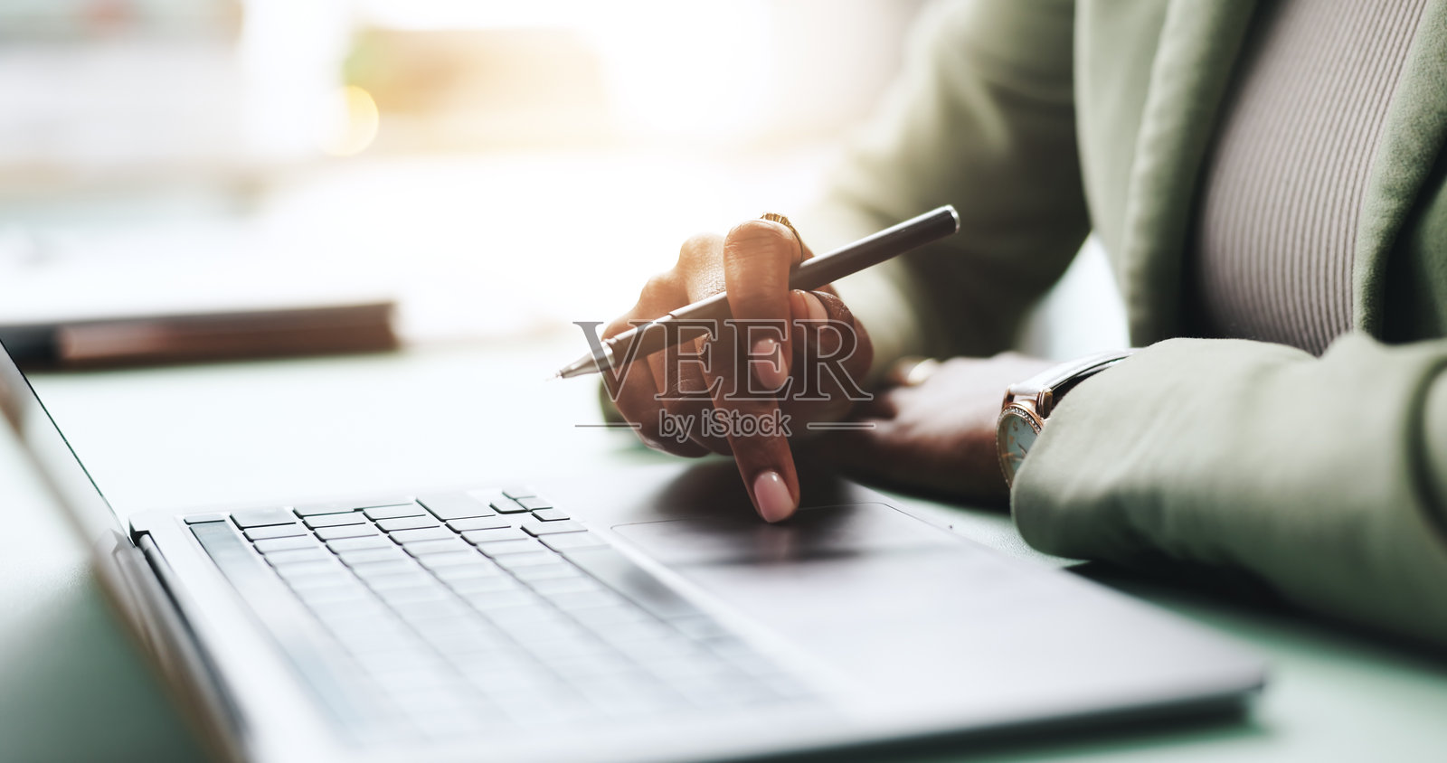 办公室里，手、笔记本电脑和商务女性正在进行研究、写作或网络新闻报道。计算机、键盘和特写镜头展示了专业新闻记者在撰写文章、创作故事和处理电子邮件。照片摄影图片