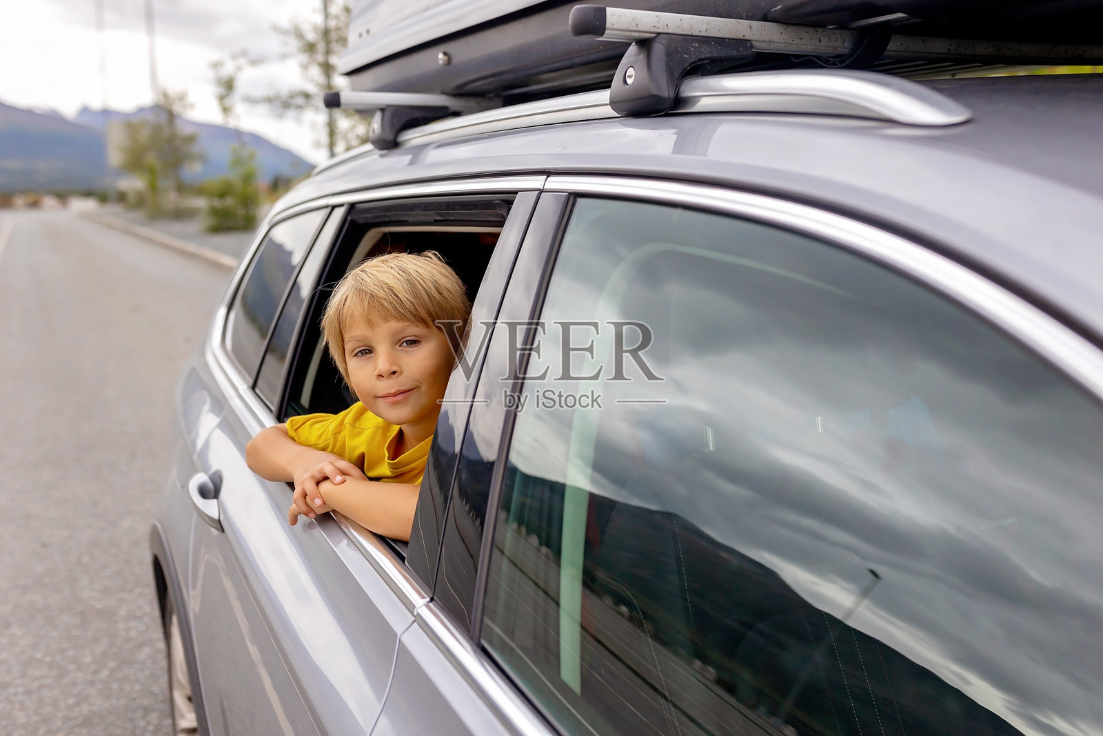 可爱的孩子从车窗里探出头，欣赏挪威洛弗敦群岛的美丽风景。照片摄影图片