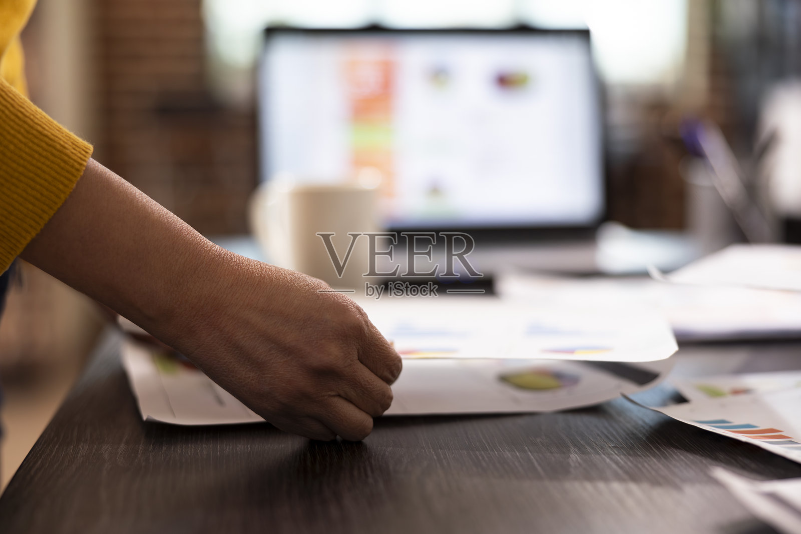 一个人手持研究论文放在桌子上照片摄影图片