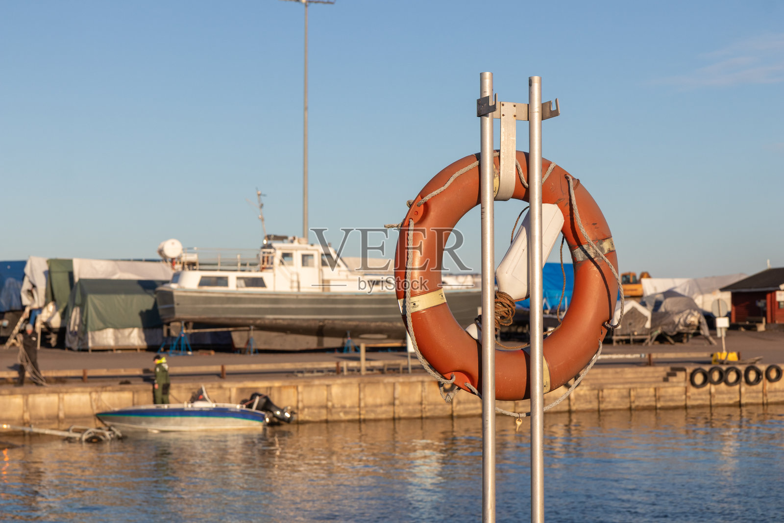 SOS海洋紧急概念。橙色救生圈竖直放置，随时准备使用。芬兰码头的救生圈特写。照片摄影图片
