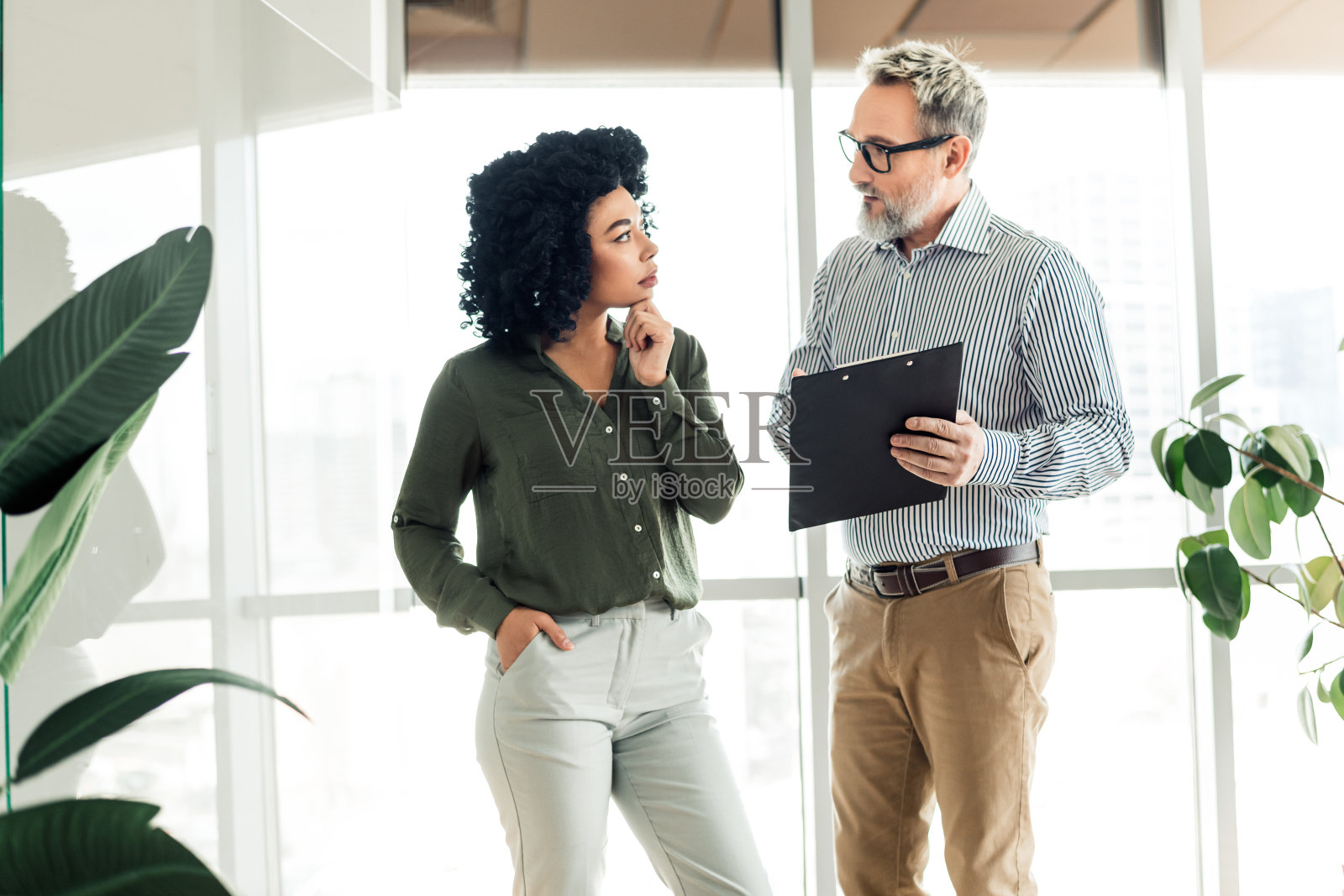 年轻的职业女性在现代办公室环境中与导师讨论商业项目以促进合作照片摄影图片