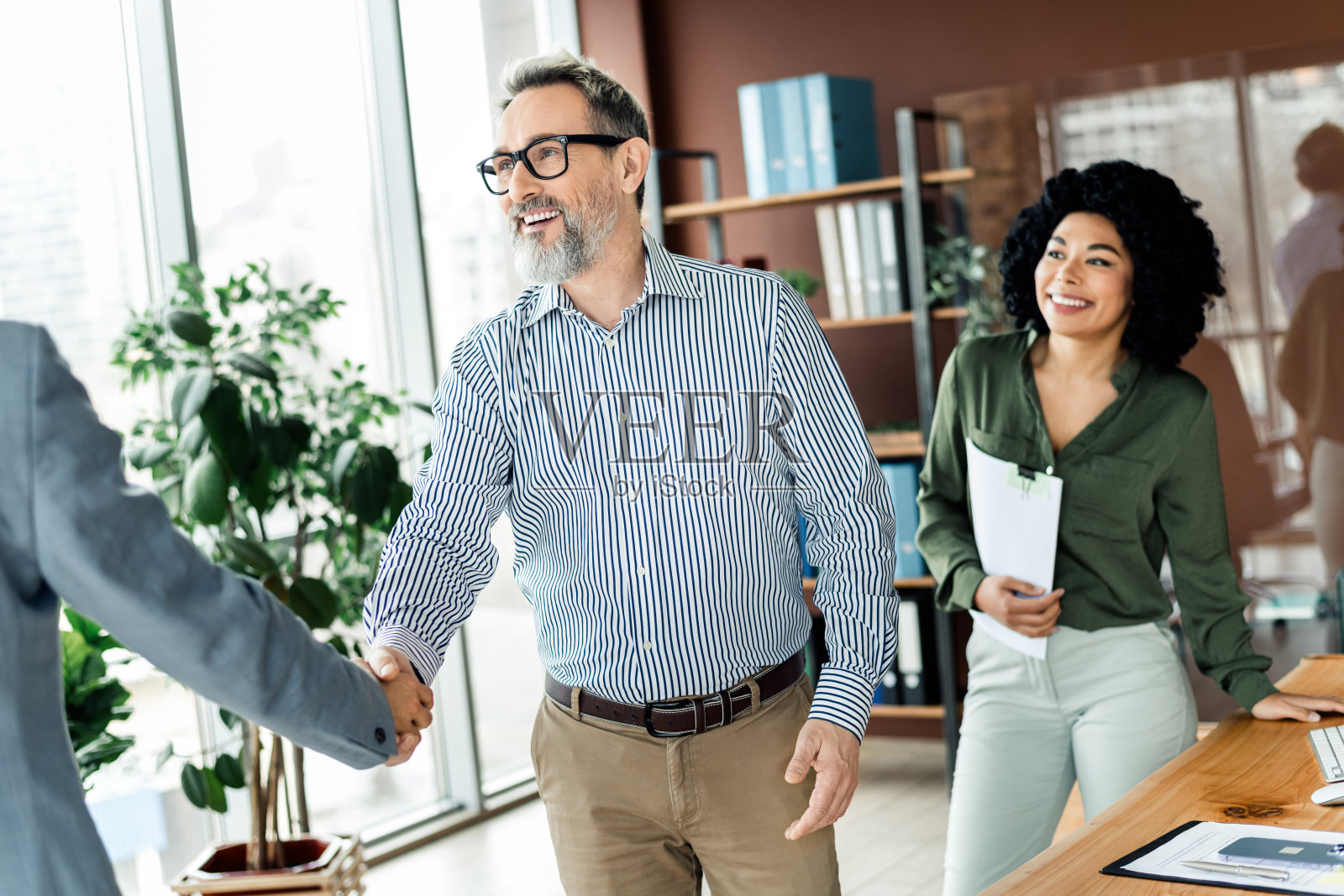 明亮的办公室工作空间中，专业团队合作展示同事们在一次引人入胜且成功的会议中的协作。照片摄影图片