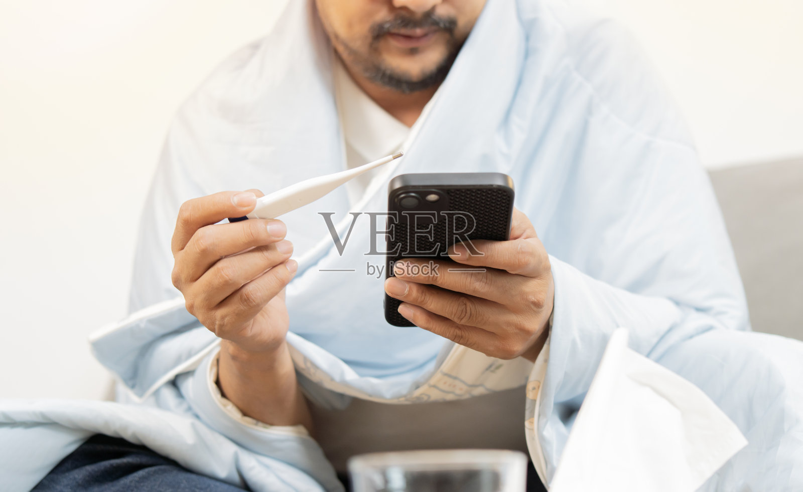 生病的流感患者拿着温度计测量体温，并附有医疗信息照片摄影图片