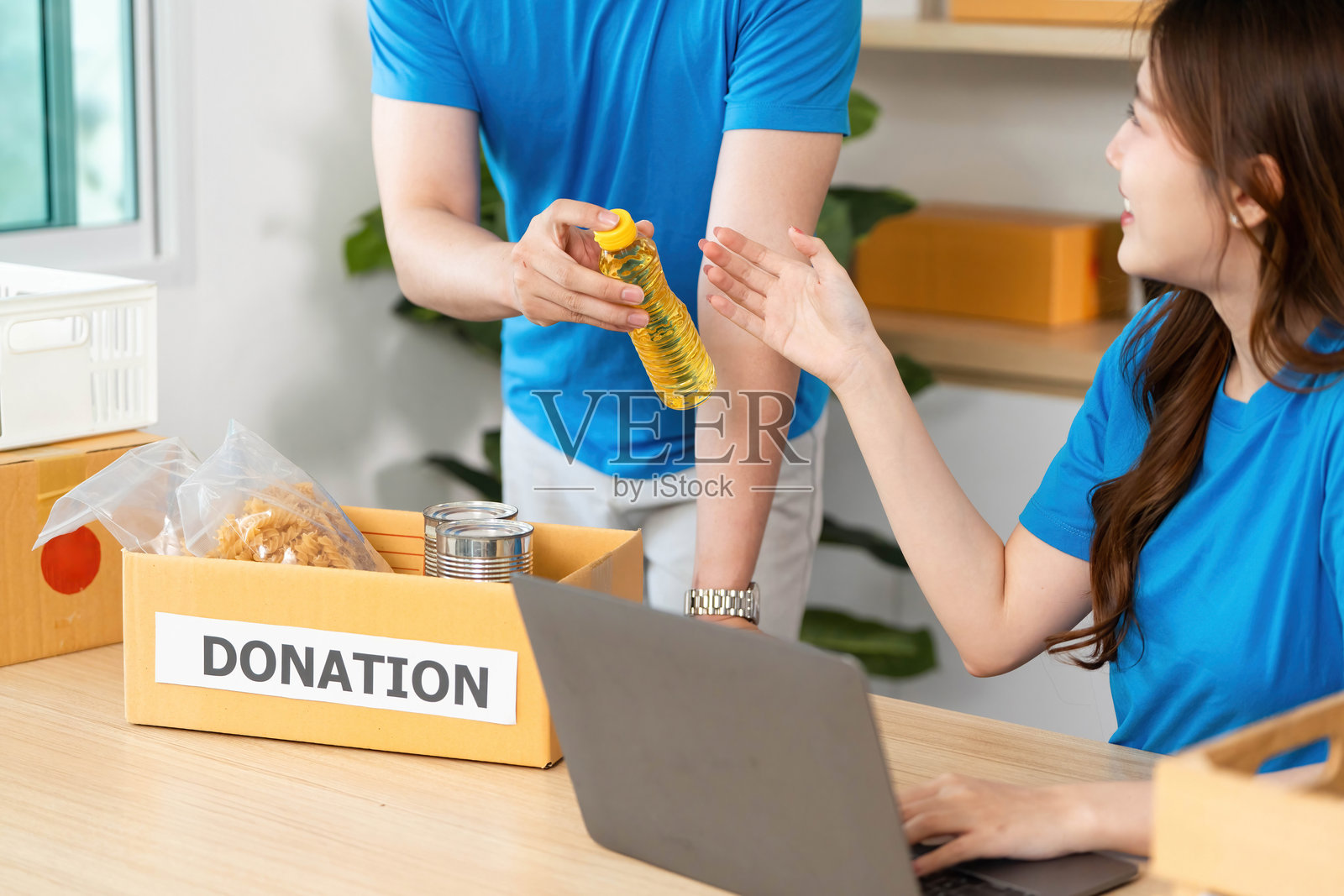 捐赠流程。志愿者在社区中心组织食品和饮料捐赠。照片摄影图片