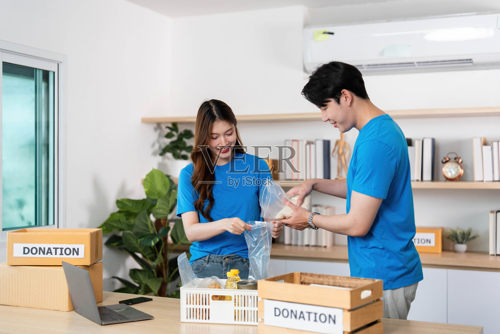 食品捐赠倡议。志愿者为社区支持准备包裹。照片摄影图片