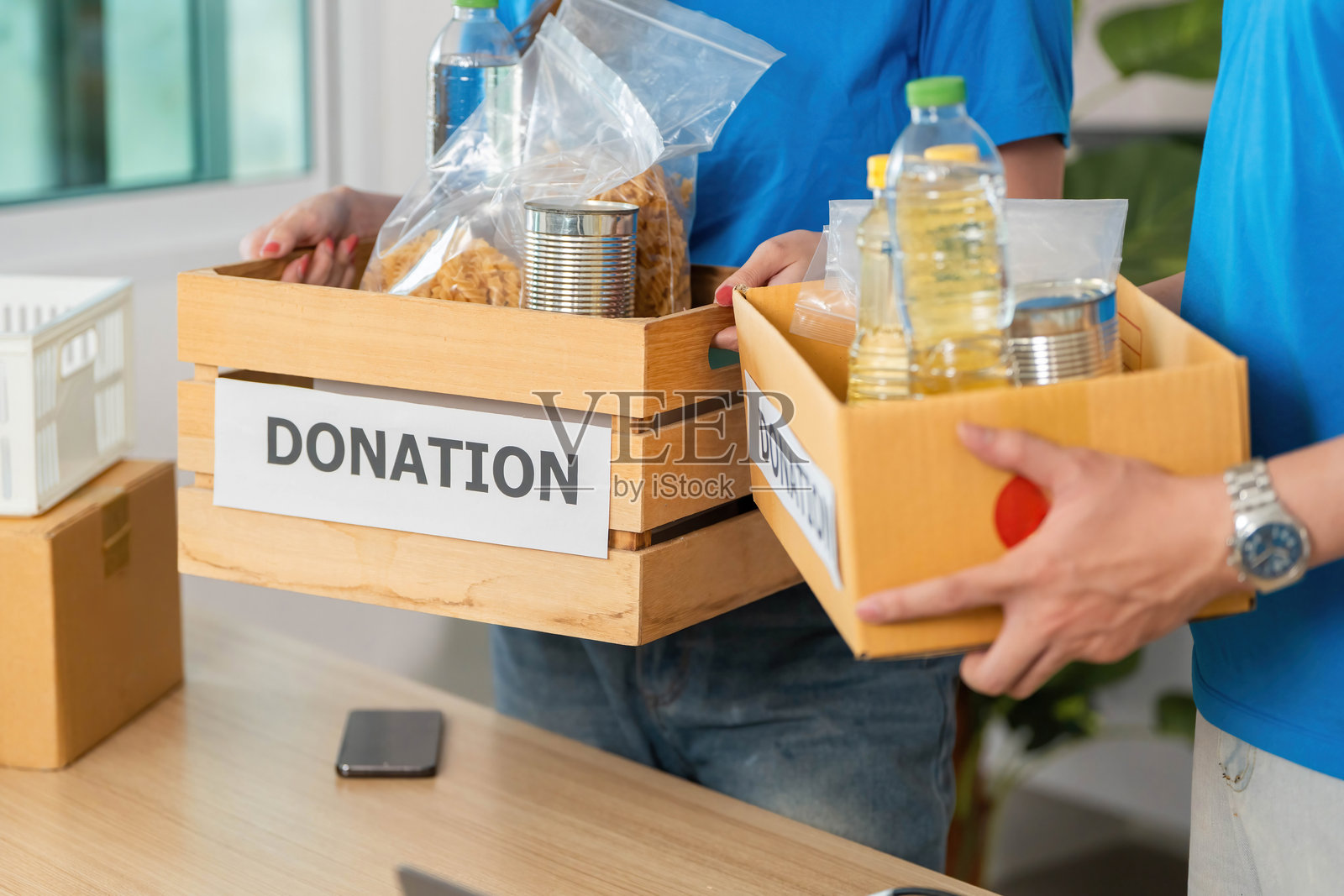 捐赠过程。志愿者们携带装满必需品的捐赠箱。照片摄影图片