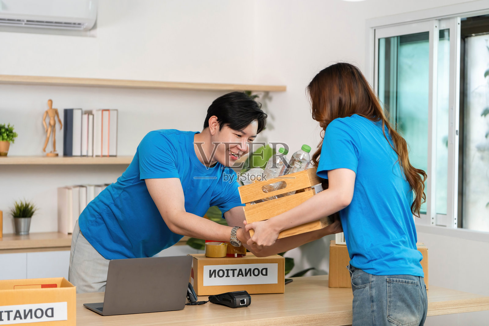 捐赠活动。志愿者们合作组织捐赠箱以支持慈善事业。照片摄影图片