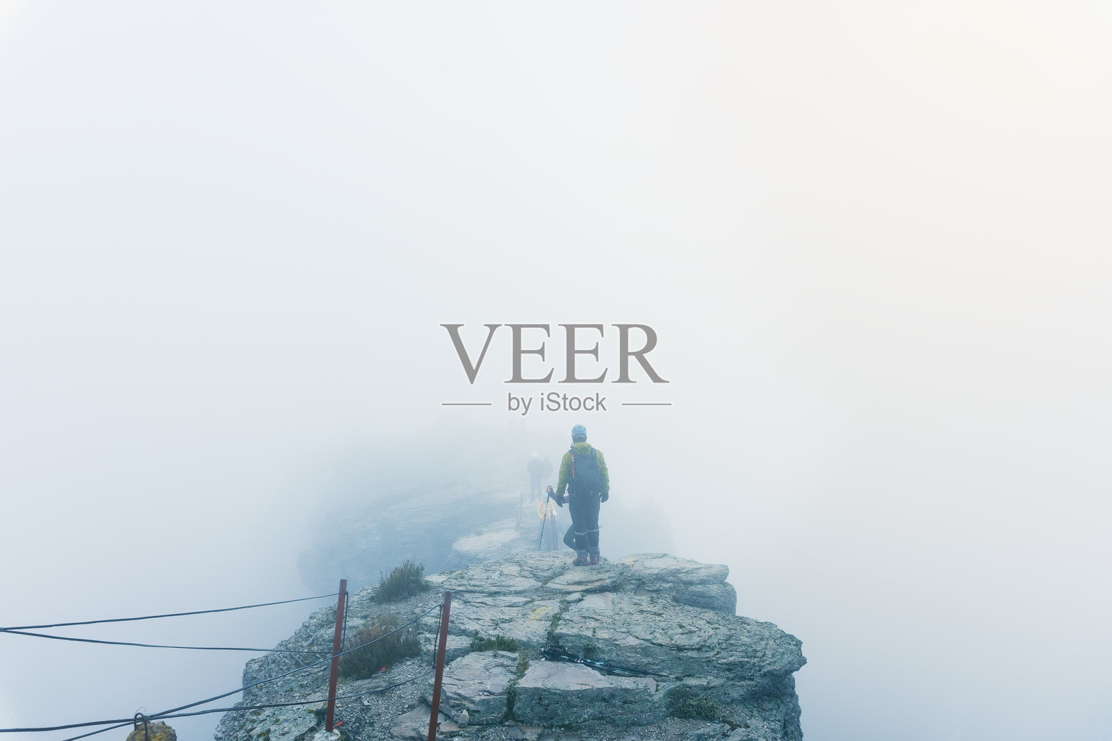 登山者在雾中征服佩罗特火山的山顶照片摄影图片