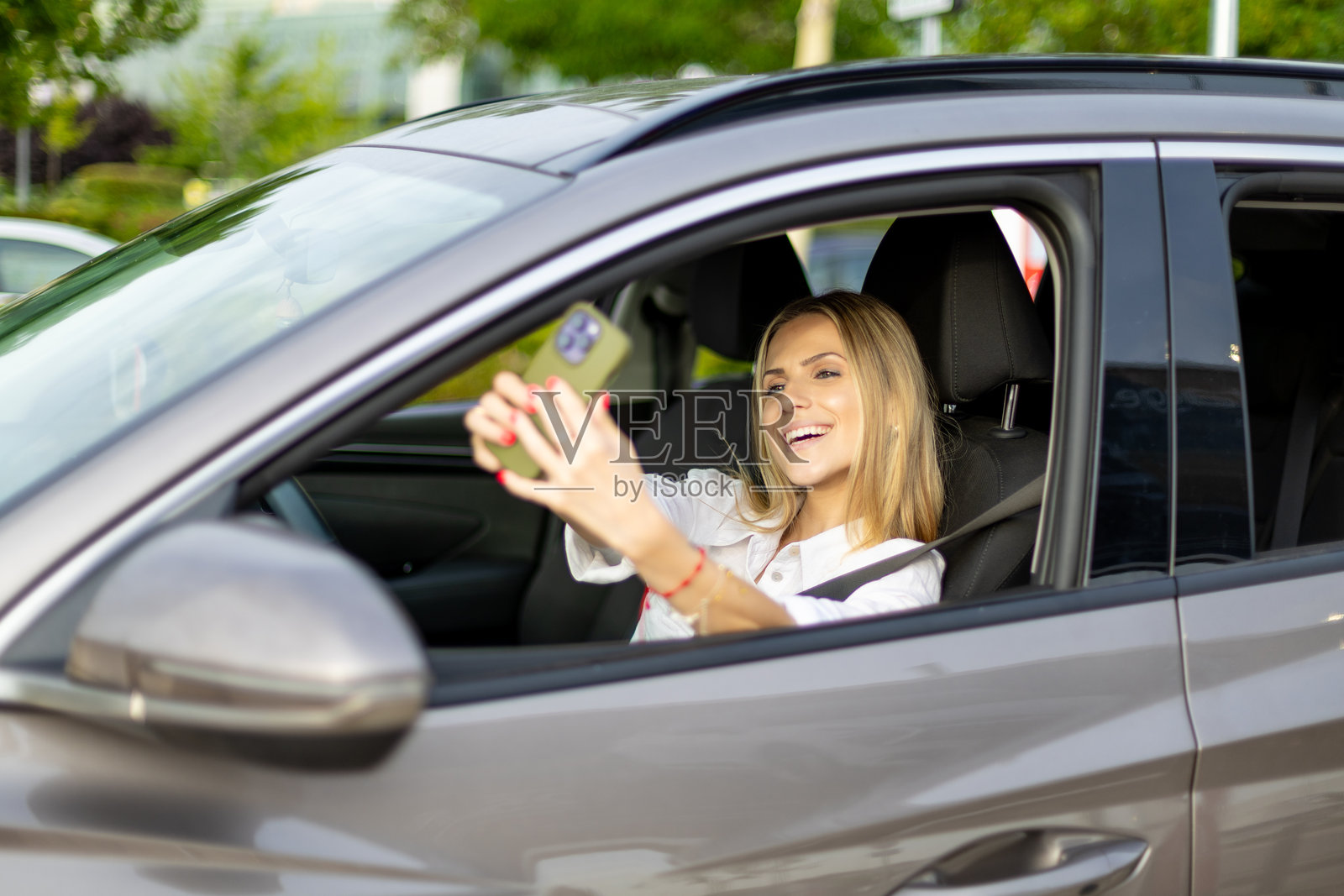 快乐的女商人在开车时自拍照片摄影图片