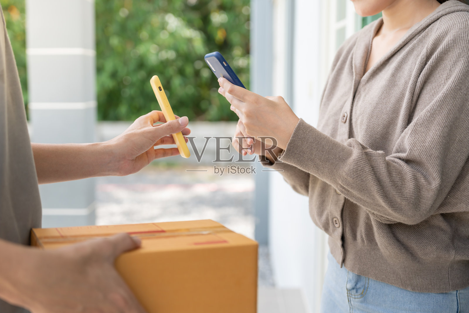 开心微笑的亚洲女性扫描二维码支付食物费用。送餐员送达快递。在线购物，纸质容器，外卖，邮递员，快递服务，包裹，电子货币，数字转账。照片摄影图片
