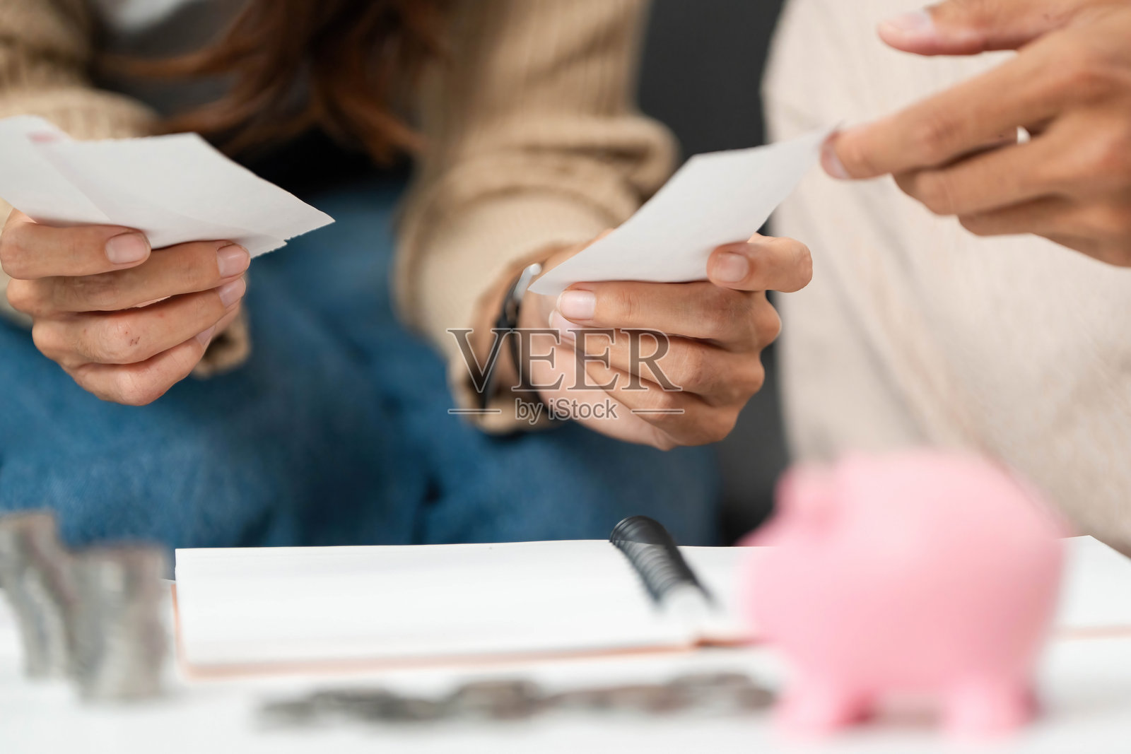 情侣进行财务审查。分析支出和储蓄，旁边有一个储蓄罐。照片摄影图片