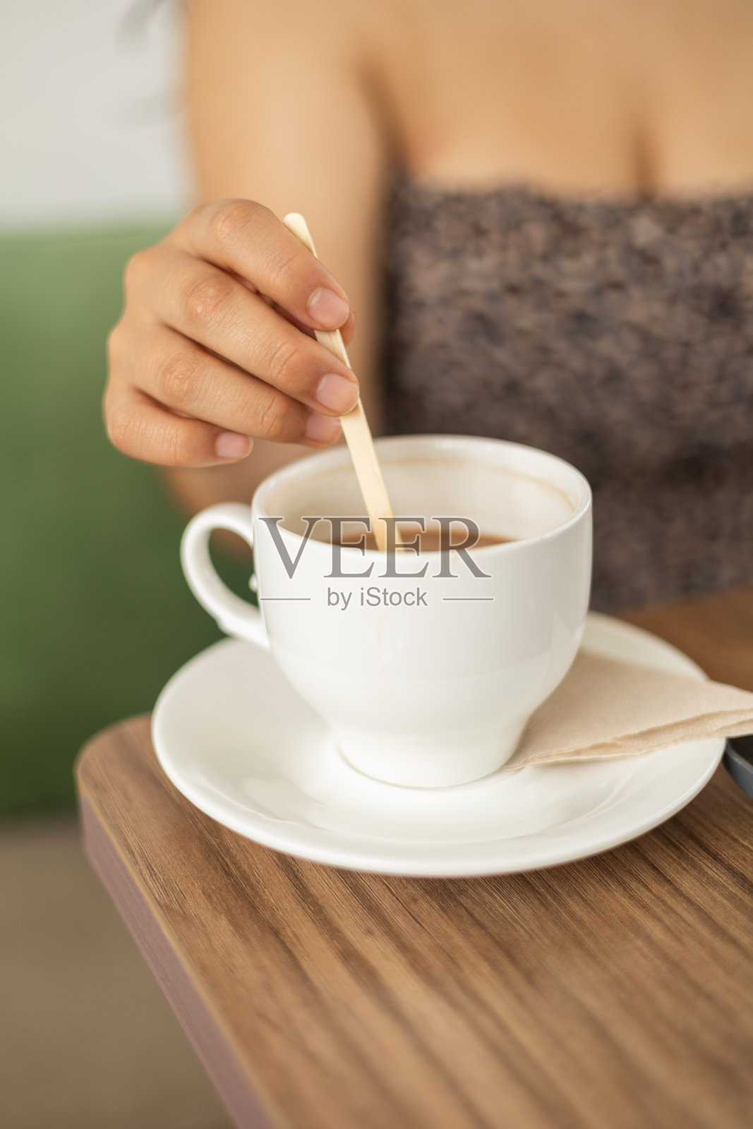 女孩在杯子里搅拌咖啡照片摄影图片