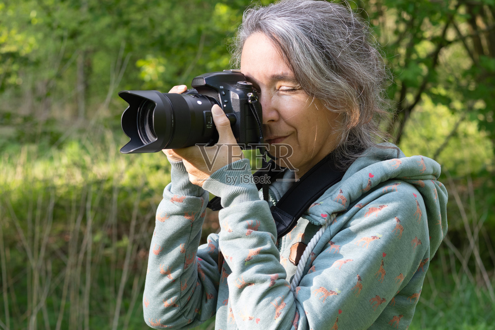 在大自然中用单反相机拍照的女性照片摄影图片