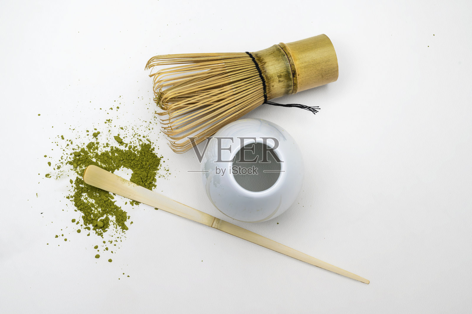 传统竹制茶刷、勺子和洒落在白色背景上的抹茶粉。制作抹茶绿茶的配件。俯视图照片摄影图片