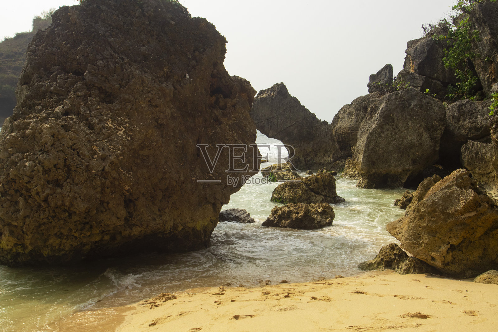 印度尼西亚热带海滩上的自然海拱和岩石悬崖照片摄影图片