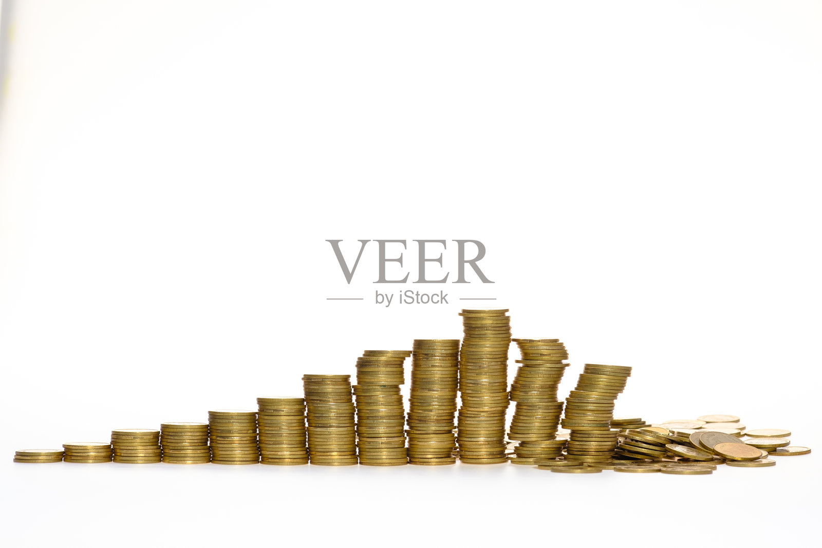 旧的和使用过的金币堆叠在一起，旁边有一个小金色钱包，背景为白色。照片摄影图片