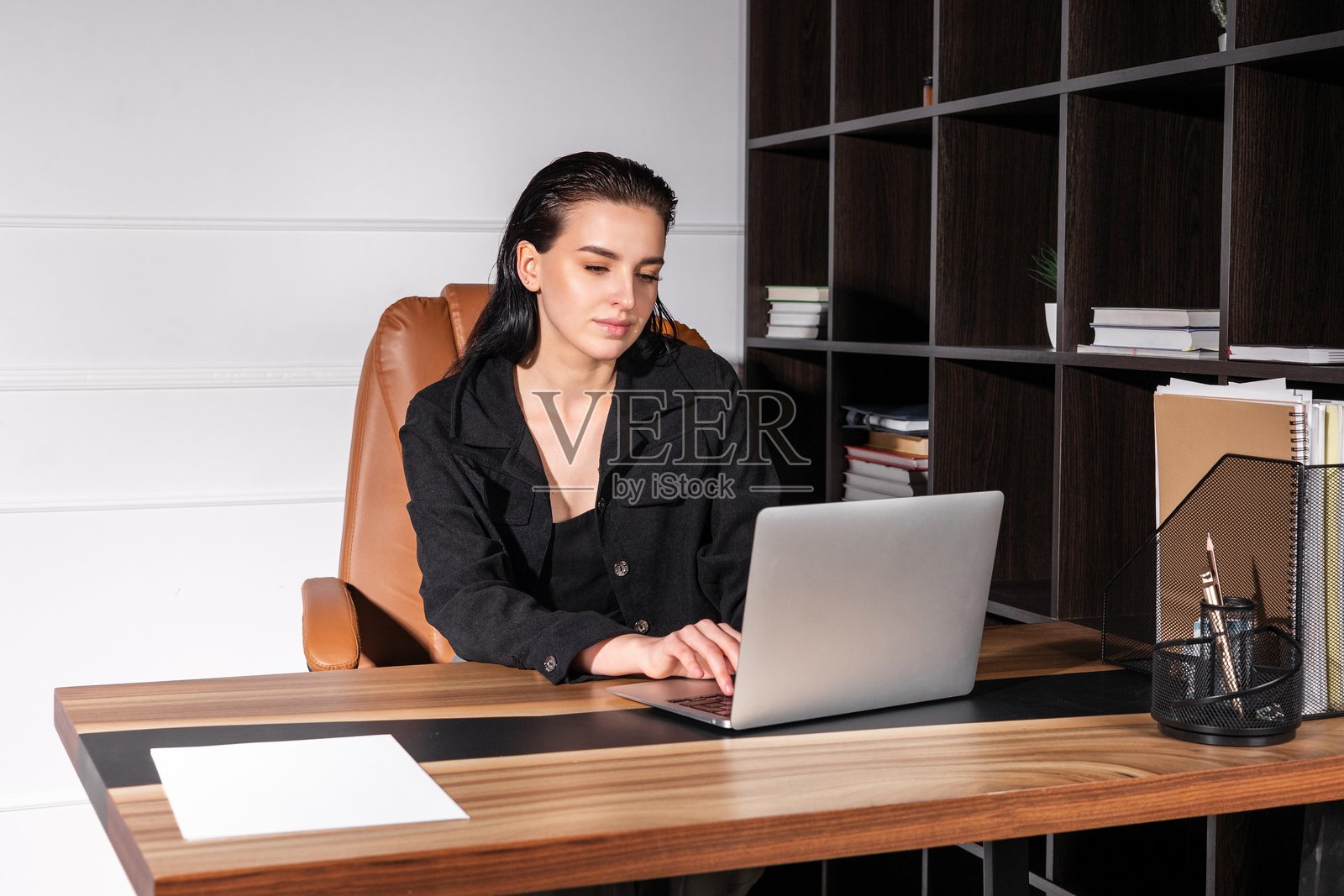 年轻女性在时尚的家庭办公室里白天使用笔记本电脑工作照片摄影图片