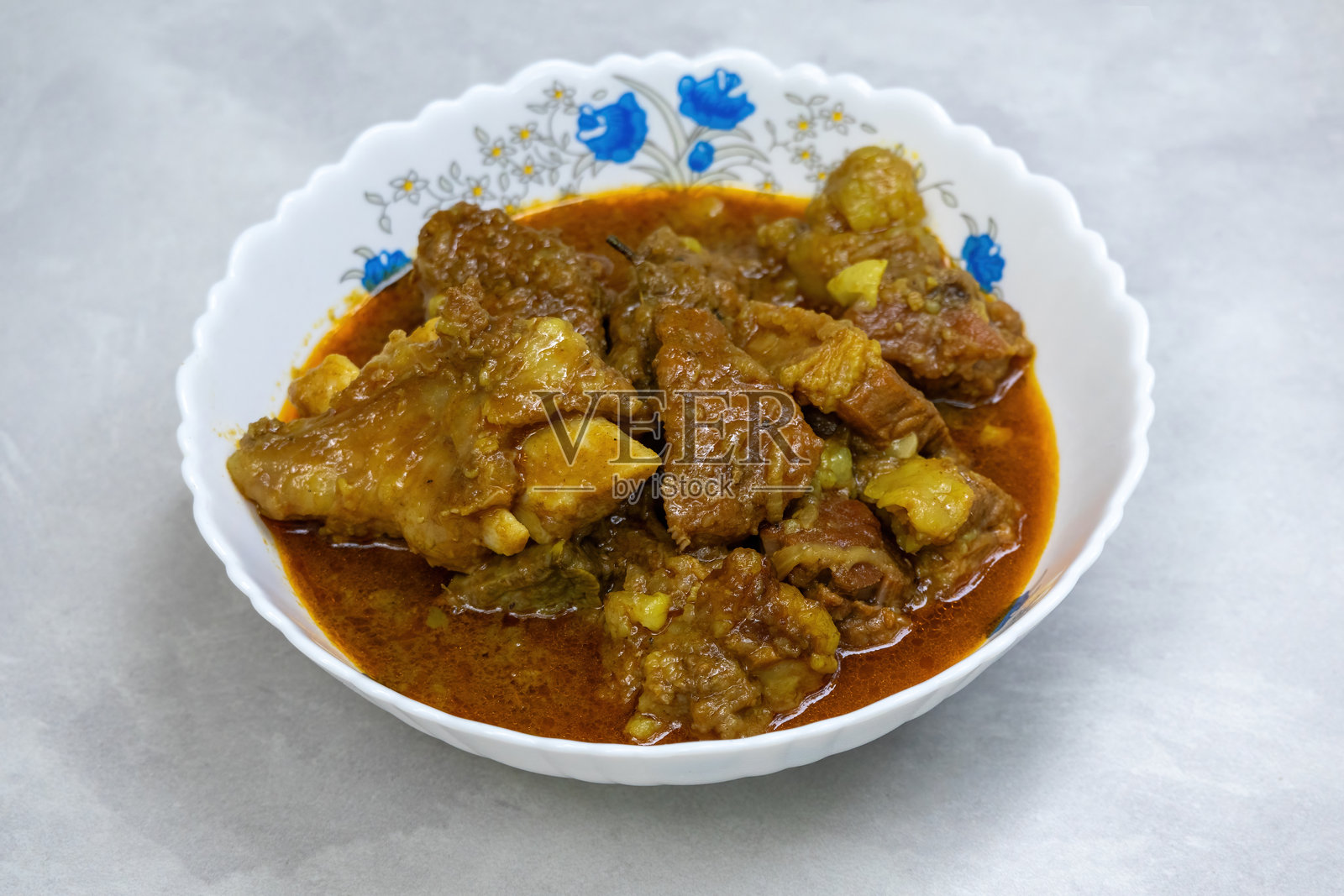 美味的自制牛肉咖喱盛在白色碗中。油腻、健康、富含蛋白质的餐点。照片摄影图片