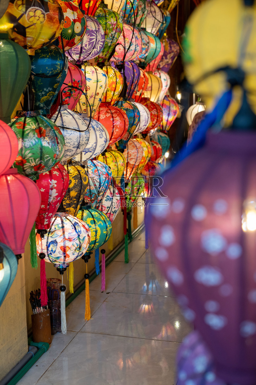 五彩缤纷的灯笼优雅地悬挂在商店的墙上，增添了魅力照片摄影图片