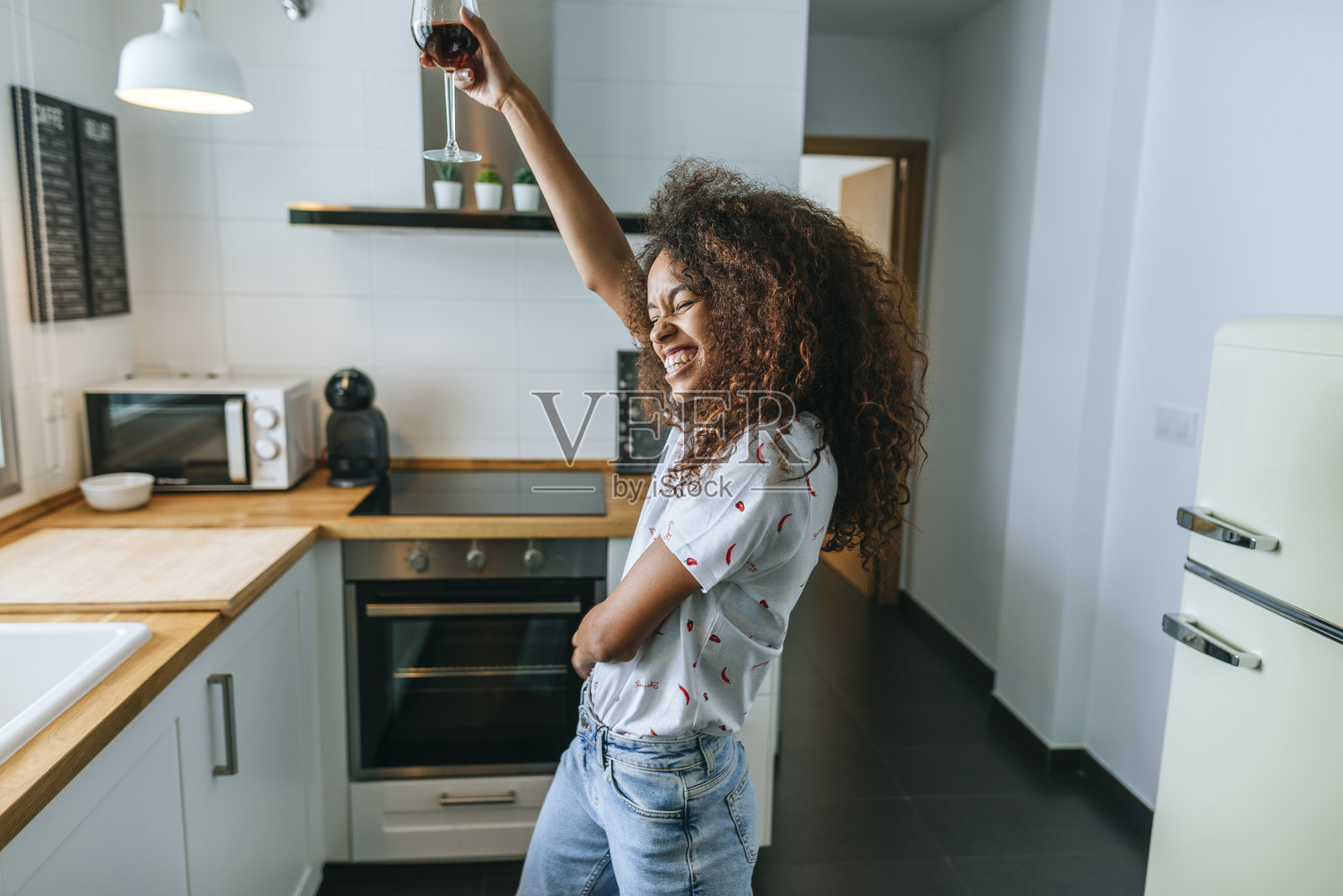 女人在厨房里一边喝雪莉酒一边跳舞照片摄影图片