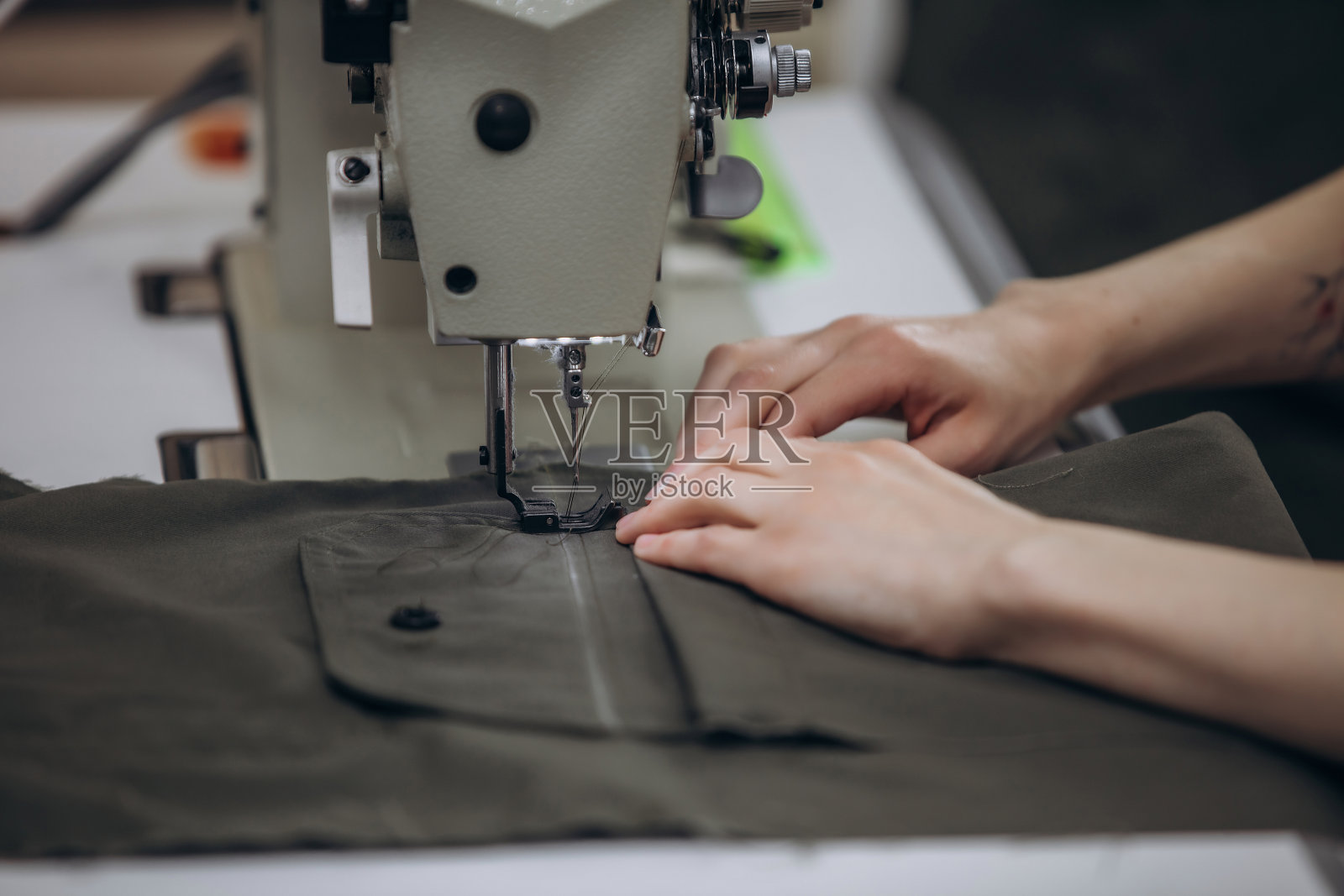 缝纫师在缝纫工作室使用缝纫机，手部特写，小型企业照片摄影图片