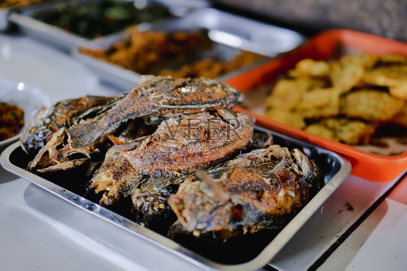 自助餐摊位提供炸鱼。照片摄影图片