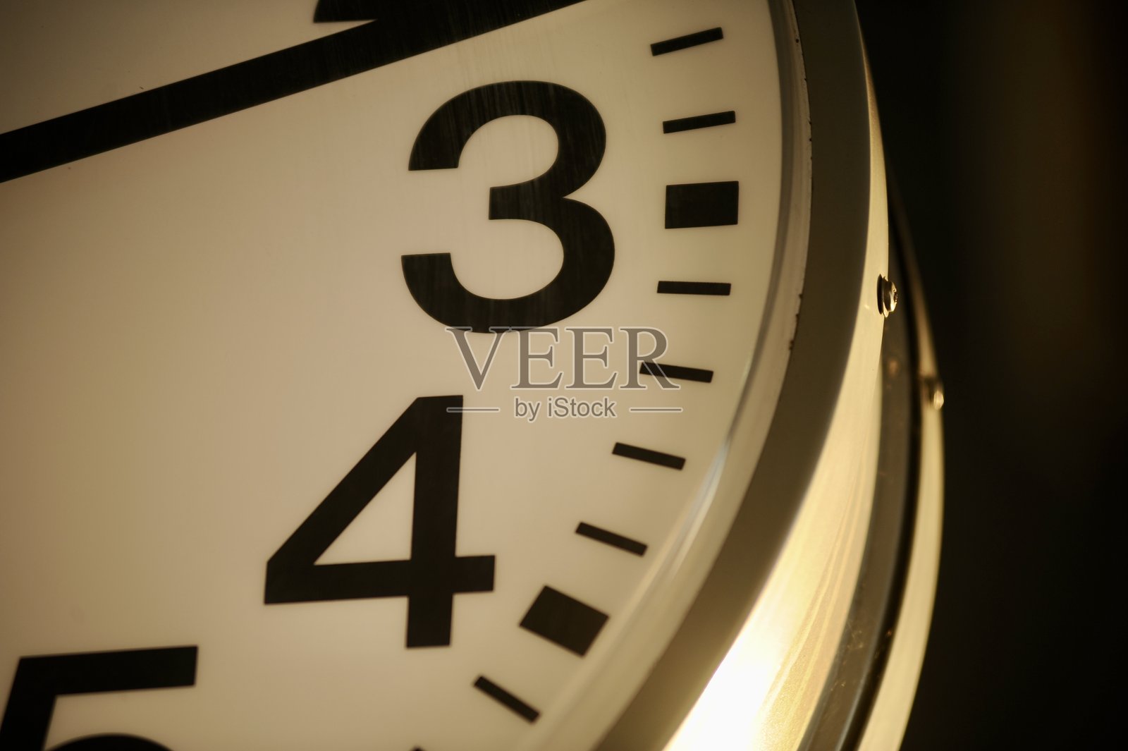 从三点钟位置拍摄的模拟时钟侧面视图，显示时针和分针在运动中照片摄影图片