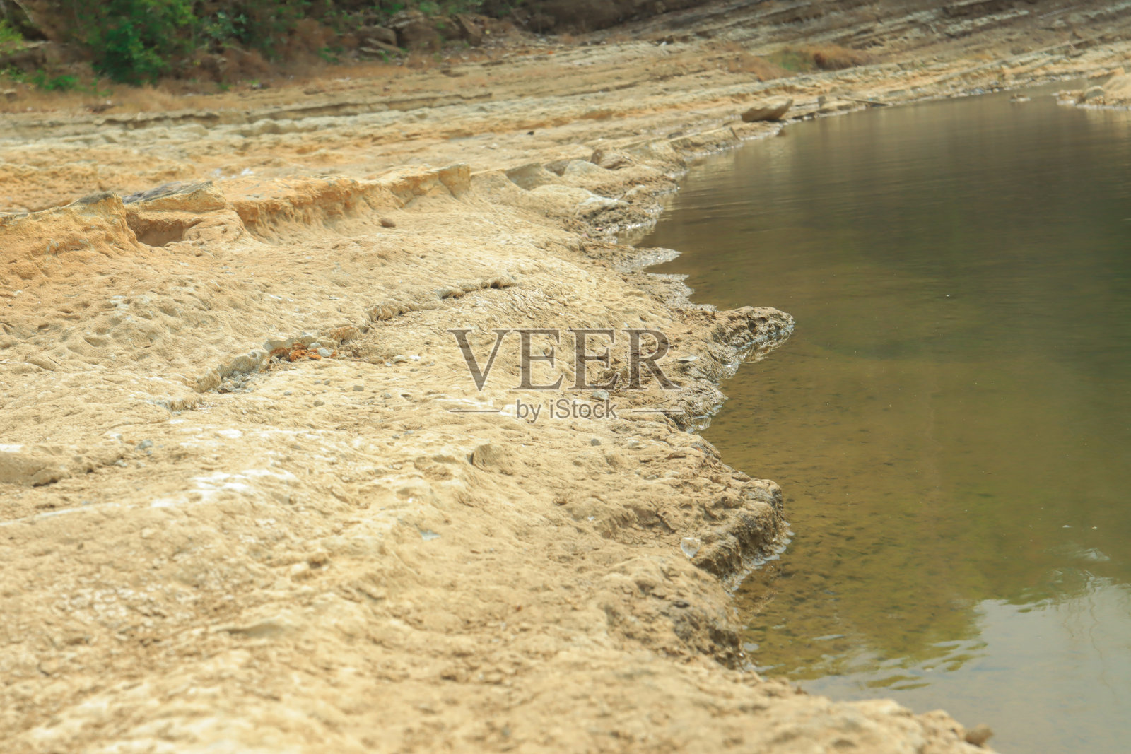 印度尼西亚平静水面旁的侵蚀岩石河岸照片摄影图片