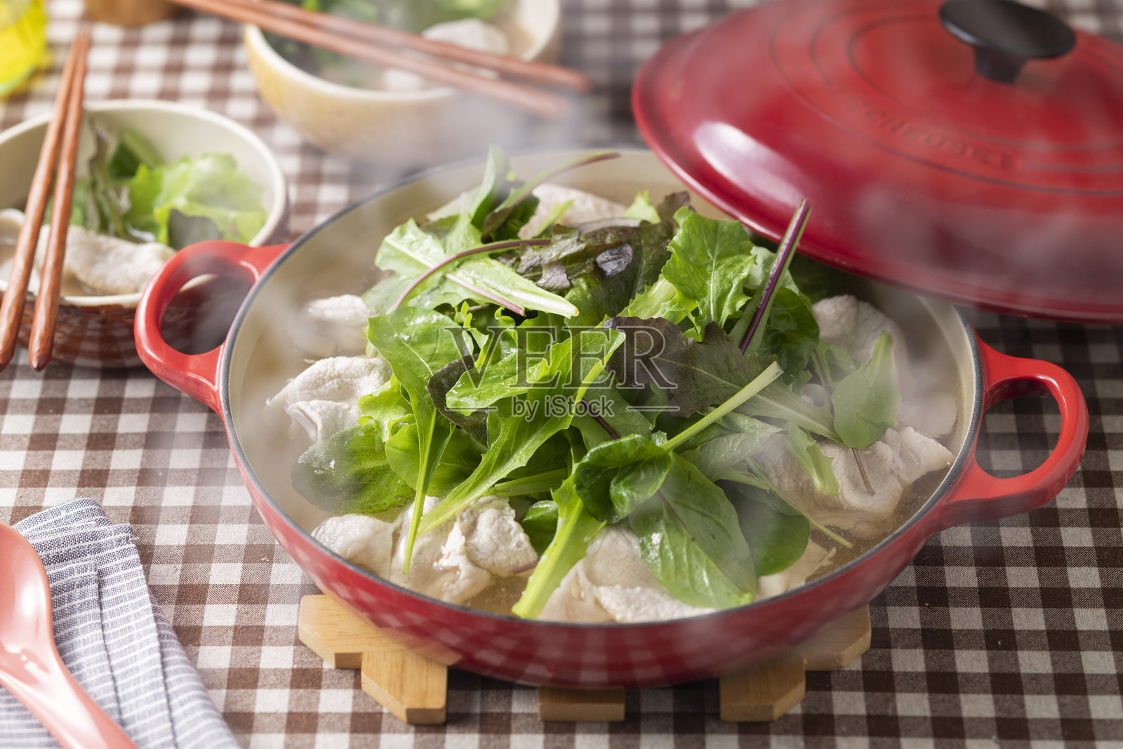 猪肉涮涮锅配丰富的嫩叶蔬菜照片摄影图片